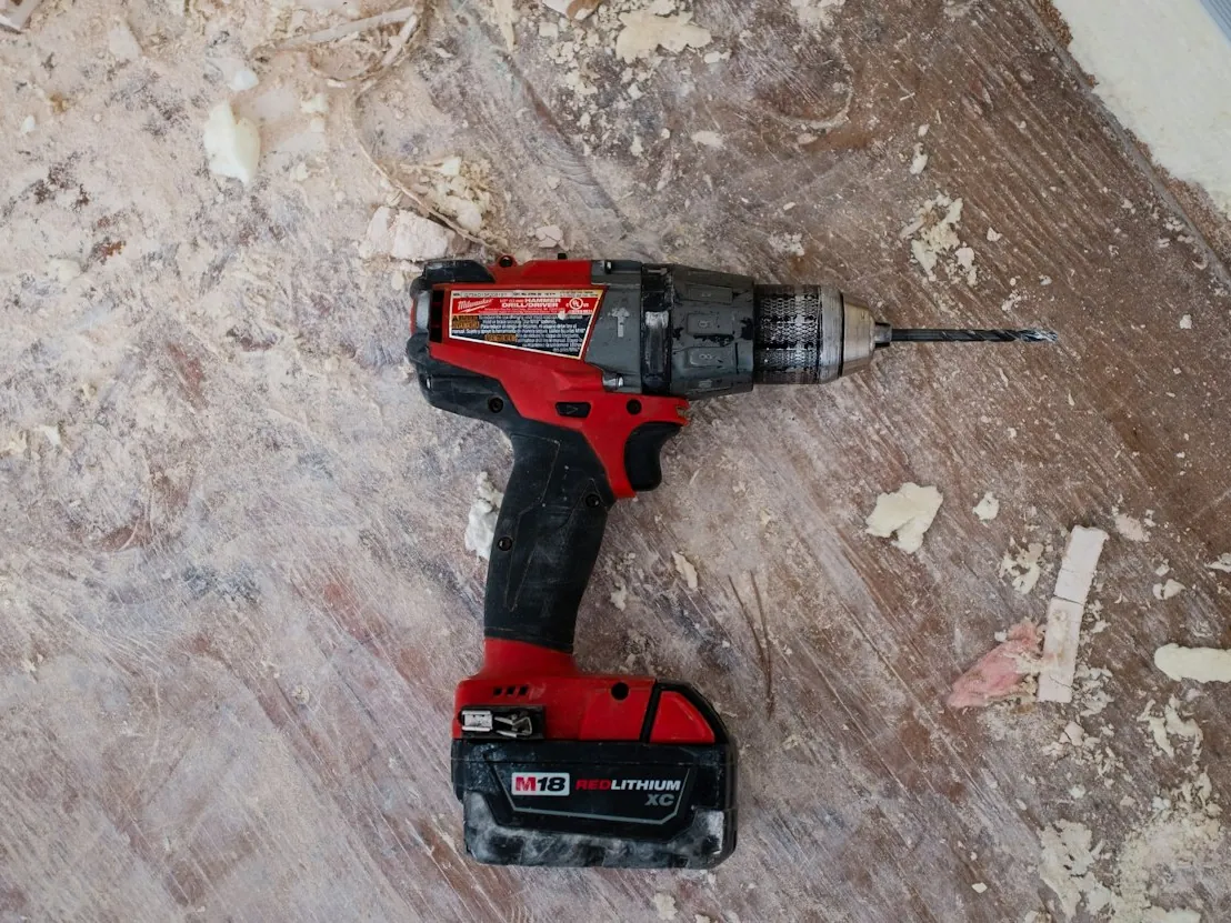 Cordless drill resting on a worn work surface